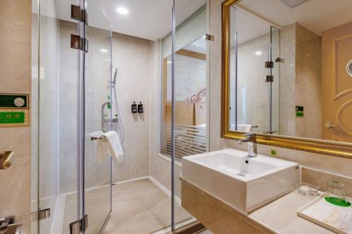 a bathroom with a sink and a shower with a mirror at Vienna Hotel Shenzhen Guangming Guangqiao Road Tianliao in Shenzhen