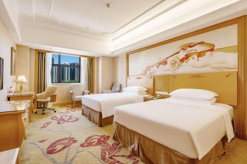 a hotel room with two beds and a desk at Vienna Hotel Shenzhen Guangming Guangqiao Road Tianliao in Shenzhen