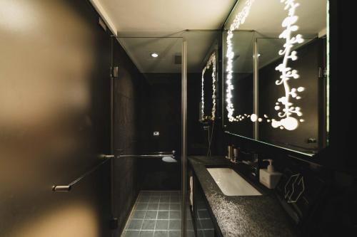 a bathroom with a sink and a mirror at SWIIO Hotel Ximending in Taipei