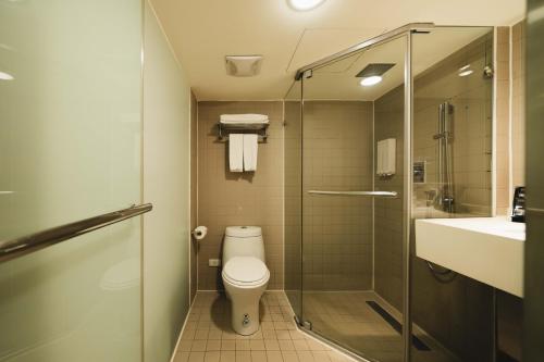 a bathroom with a toilet and a shower and a sink at SWIIO Hotel Ximending in Taipei