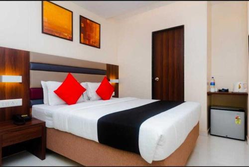 a bedroom with a large bed with red pillows at Hotel Regal International - Near Mumbai International Airport Andheri East in Mumbai