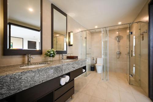 a bathroom with two sinks and a shower at Emerald Ho Tram Resort in Ho Tram