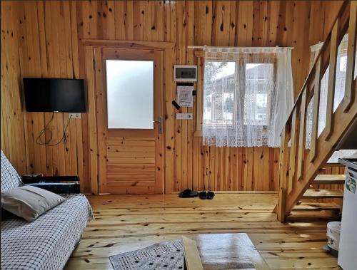 salon z kanapą, telewizorem i drzwiami w obiekcie Şahan Bungalov w mieście Gökçe