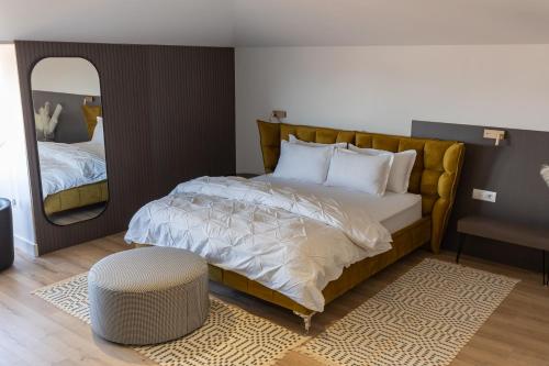 a bedroom with a large bed and a mirror at Vila Kace in Korçë