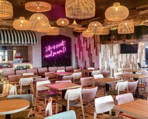 a restaurant with tables and chairs and chandeliers at Caravan on luxury Devon holiday park in Paignton