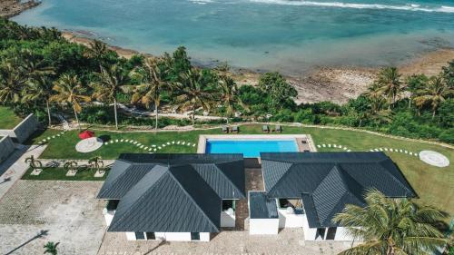 an aerial view of a resort with a swimming pool and the ocean at Morika Villa in Rua