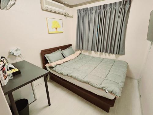 a small bedroom with a bed and a desk at K Highstel Uijeongbu 35 in Uijeongbu