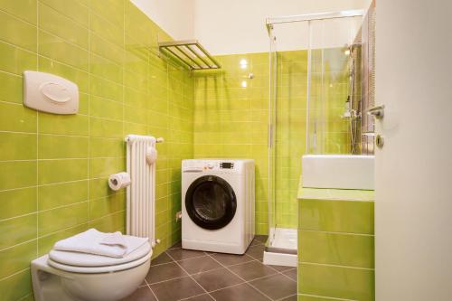 un bagno piastrellato verde con lavatrice di Apartment Ponte Tesina a Costermano