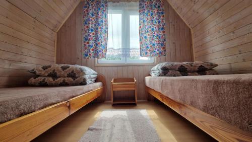 a bedroom with two beds and a window at Zielona Przestrzeń in Polańczyk