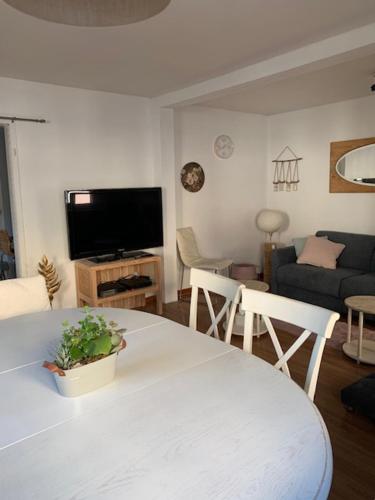 a living room with a white table and a couch at la Maison d'à coté de Strasbourg in Illkirch-Graffenstaden