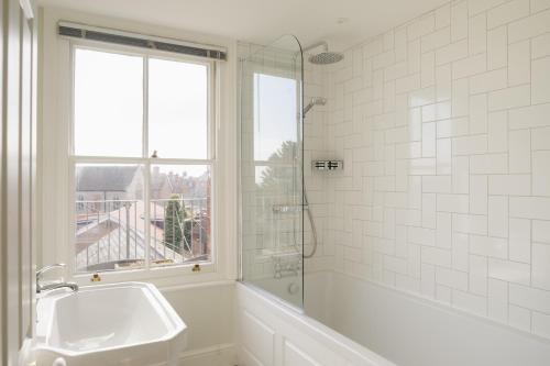 a white bathroom with a sink and a shower at High View, Southwold High Street (2 bed, 2 bath, allocated parking, balcony) in Southwold