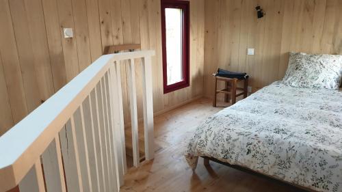 - une chambre avec un lit et un escalier dans l'établissement L 'Echo des bois, à Ambillou-Château