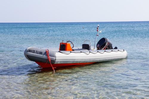 a red and white boat sitting in the water at Margarita Apartments in Ierápetra