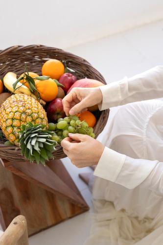 a man holding a basket of fruit on a table at Zannos Luxury Suites By Zannos Collection in Pirgos