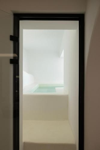a glass door in a room with a shelf at Zannos Luxury Suites By Zannos Collection in Pirgos