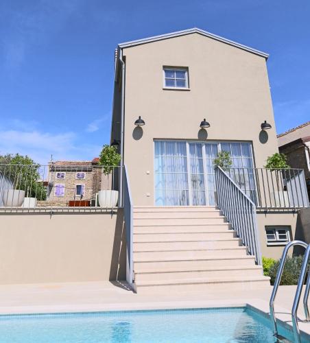 a house with a swimming pool in front of a house at Villa Volare Cantare with 2 br, a heated pool and panoramic view near Buje, Istra in Momjan