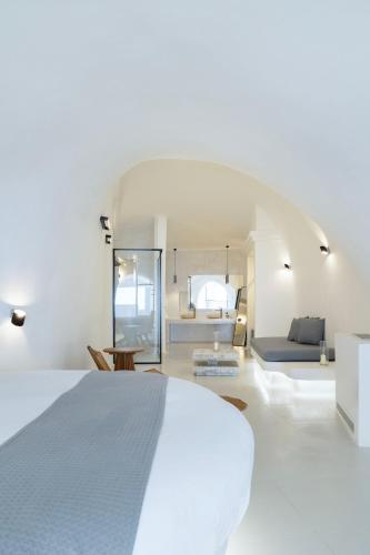 a white bedroom with a white bed and a couch at Zannos Luxury Suites By Zannos Collection in Pirgos