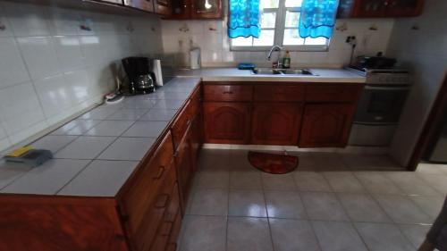 a kitchen with wooden cabinets and a sink at villa nikiboko Bonaire in Kralendijk
