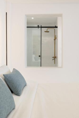 a white bedroom with a shower and a bed at Zannos Luxury Suites By Zannos Collection in Pirgos