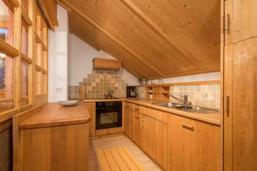 a kitchen with wooden cabinets and a sink at Lusina Apartments in Luson