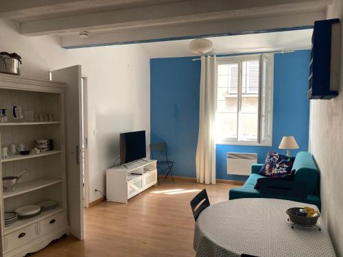 - un salon bleu avec une table et un canapé dans l'établissement Appartement à 2 pas du Port de la Ciotat, à La Ciotat
