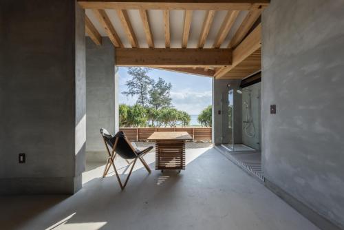 a table and a chair in a room with a view at Amami 与庵 in Amami
