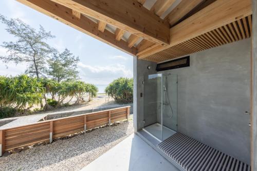 a bathroom with a shower with a view of the ocean at Amami 与庵 in Amami