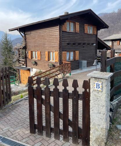 a wooden house with a fence in front of it at Chalet Aledia in Pessinetto