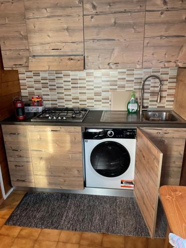 a kitchen with a stove and a sink and a dishwasher at Chalet Aledia in Pessinetto