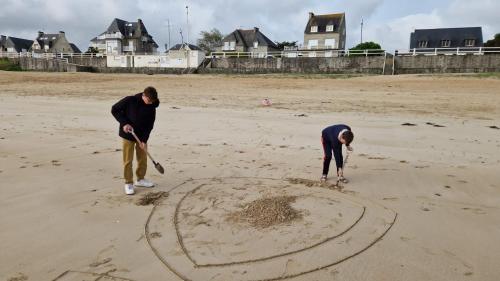 2 personnes jouant dans le sable sur la plage dans l'établissement Au coeur de Saint Cast, à Saint-Cast-le-Guildo