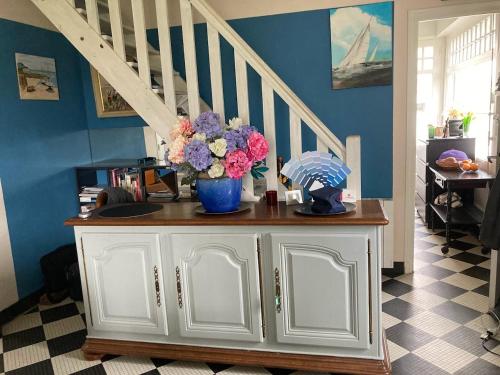 Cette chambre dispose d'une armoire avec un vase de fleurs. dans l'établissement Au coeur de Saint Cast, à Saint-Cast-le-Guildo