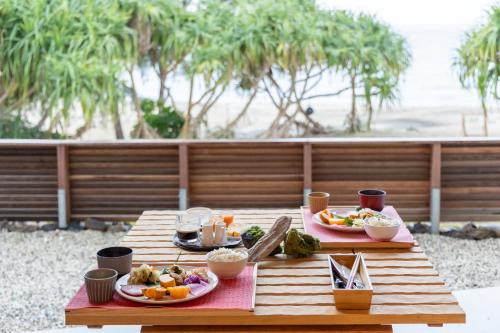 a wooden table with two plates of food on it at Amami 与庵 in Amami