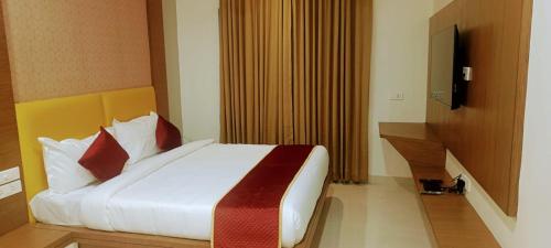 a bedroom with a large bed with red pillows at HOTEL ORCHID VISTA in Tirupati