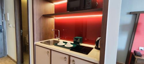 a kitchen with a sink and a microwave above a mirror at Bstudio in APEC Mandala Mũi Né in Phan Thiet