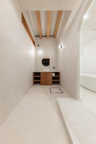 a room with white walls and a tv on a wall at Amami 与庵 in Amami