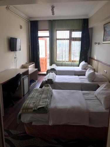 Cette chambre comprend 4 lits et un bureau. dans l'établissement otel sema, à Altındağ