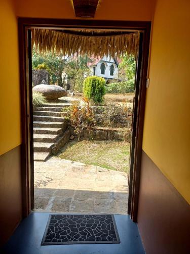 an open door with a view of a yard at Iartong Guest House in Mawlynnong