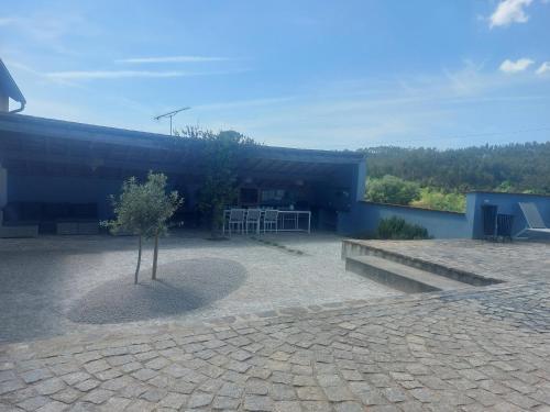 un edificio con un árbol en medio de un patio en Casa Bem Estar, en Mortágua