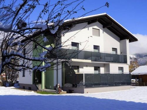 Mauthen的住宿－Gorgeous luxurious house with large garden close to the town centre and piste，白色的建筑,在雪中设有阳台