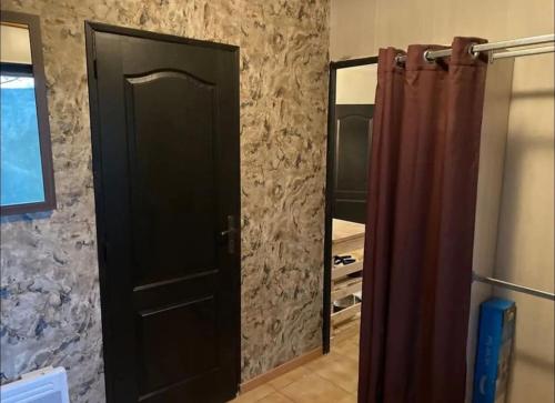 a black door in a room with a mirror at Gîte de Kim in Ferques