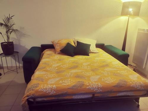 - un lit avec une couette jaune dans l'établissement Belharra Appartement, à Bayonne