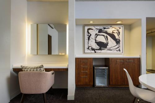 een woonkamer met een tafel en een spiegel bij Renaissance Palm Springs Hotel in Palm Springs