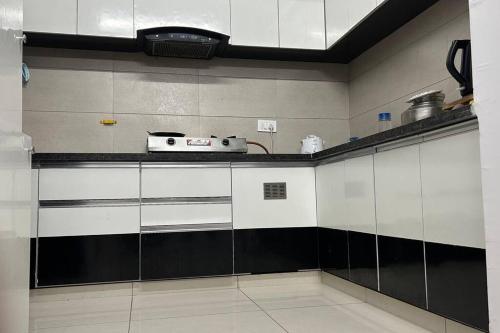 una cocina con armarios blancos y un aparato en la encimera en Saral Sky Near Agora Mall, en Ahmedabad