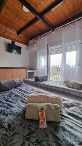 a large bedroom with two large beds and a large window at U Bloku in Donji Miholjac