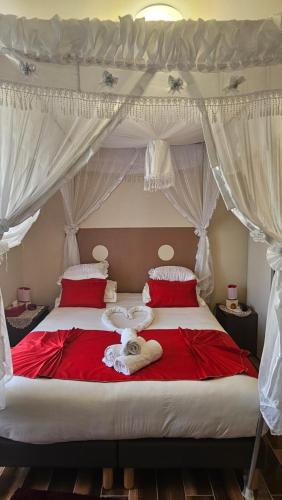 um quarto com uma cama grande e lençóis vermelhos em Esprit Etape em Saint-Barthélemy-de-Vals