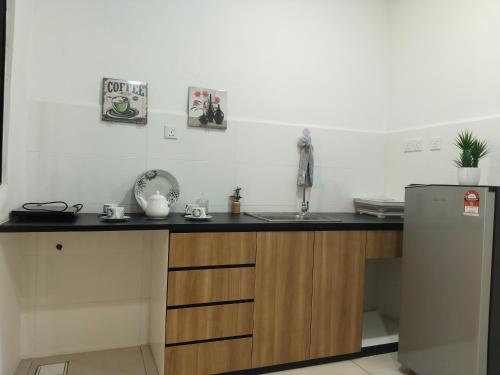 a kitchen with a sink and a refrigerator at ITCC Manhattan Suites by Kansayan Homestay in Penampang