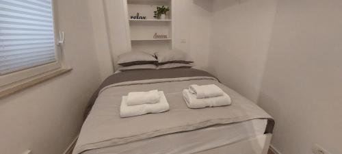 1 dormitorio con 1 cama con 2 toallas en Apartment Kremen en Izola