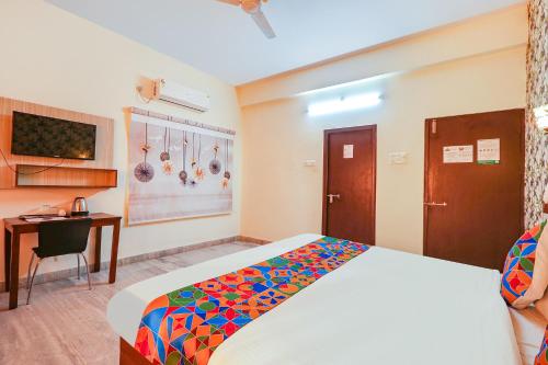 a bedroom with a bed and a desk and a computer at HOTEL NIGHT EYE HI-TECH CITY in Hyderabad