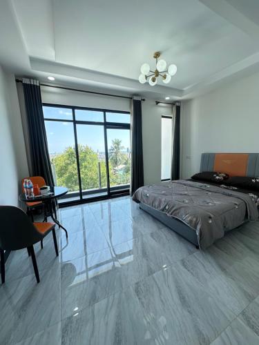 um quarto com uma cama, uma mesa e uma janela em Peaceful Homestay em Sihanoukville