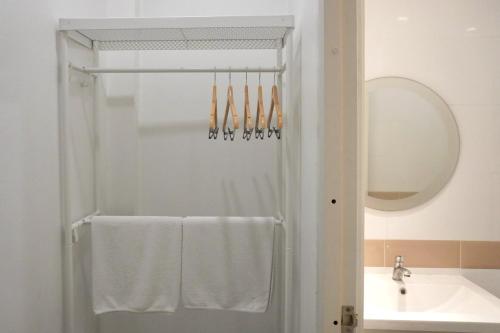 a bathroom with a shower and a sink and towels at BW Thai Art Style Hotel in Bangkok